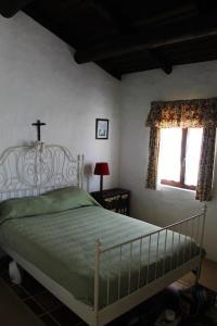 a bedroom with a bed and a window with a cross on it at Casa do Pinheiro in Alcácer do Sal