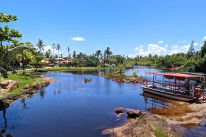 a boat is docked on a river at Casa Vilacentro - Imbassaí in Imbassai