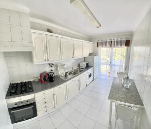 a kitchen with white cabinets and a counter top at Charming Salema in Salema