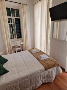 a bedroom with a large bed with two towels on it at Hospedaria Pôr do Sol in Funchal