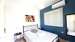 a bedroom with a blue wall with a bed at AGIOS LEON Apartment 3 in Agios Leon