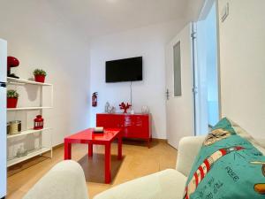 sala de estar con mesa de centro roja y TV en FUZETA MARÉ BAIXA RIA VIEW by Ethnic Ocean, en Fuseta