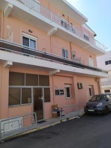 a car parked in front of a pink building at IRINIS HOUSES in Rhodes Town