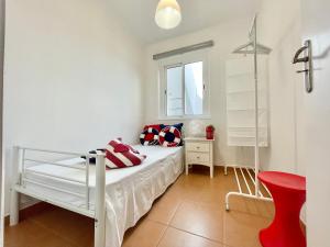 1 dormitorio con 1 cama blanca y 1 silla roja en FUZETA MARÉ BAIXA RIA VIEW by Ethnic Ocean, en Fuseta