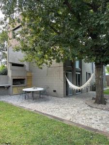una hamaca colgada de un árbol frente a un edificio en Fisherton Alquiler Temporario, en Rosario