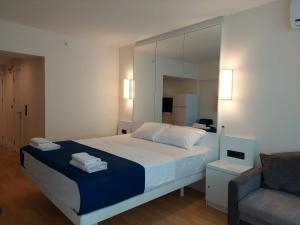 a bedroom with a bed with a mirror and a couch at lux apartments orbi city in Angisa