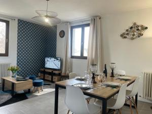 une salle à manger avec une table, des chaises et une télévision dans l'établissement Grand appartement en vallée de la loire, à Gennes