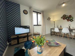 un soggiorno con TV e vaso di fiori di Grand appartement en vallée de la loire a Gennes Altre 14 foto