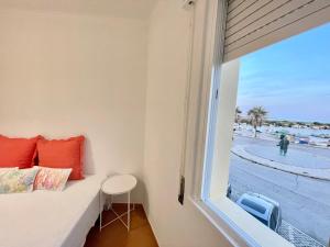 1 dormitorio con ventana y vistas a la playa en FUZETA MARÉ BAIXA RIA VIEW by Ethnic Ocean, en Fuseta