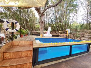 a pool with a wooden deck next to a tree at 麋宿Mi House墾丁包棟 in Hengchun