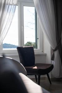 a chair sitting in front of a window at Apartment Val with sea view in Šibenik