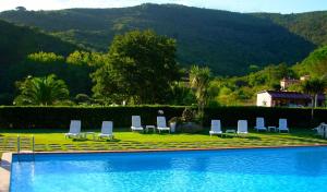 a group of lounge chairs sitting next to a swimming pool at Hotel Il Caminetto in Portoferraio