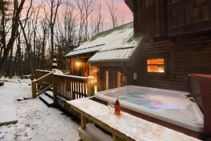 a hot tub on the side of a house in the snow at Jamesons Cabin! 8 Minutes to Wisp, HotTub, FirePit, Pets, EV Chgr in Oakland