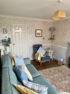 a living room with a blue couch and a chair at Clover Cottage in Haverfordwest