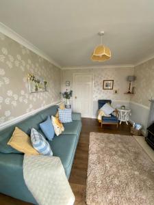 a living room with a blue couch and a rug at Clover Cottage in Haverfordwest