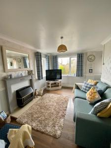 a living room with a blue couch and a tv at Clover Cottage in Haverfordwest