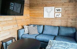un soggiorno con divano blu e tavolo di 4 Bedroom Beautiful Home In Sysslebck a Sysslebäck