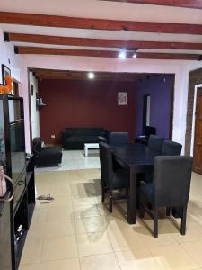 sala de estar con mesa negra y sillas en Liza’s House Ezeiza Airport en Monte Grande