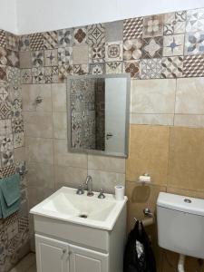 uma casa de banho com um lavatório, um WC e um espelho. em Liza’s House Ezeiza Airport em Monte Grande