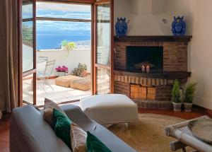 a living room with a couch and a fireplace at Donna Rachele in Aci Castello