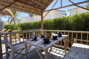 una mesa de madera con copas de vino en el patio en Manao Pool Villa 12 - 5 Mins Walk To The Beach, en Ko Lanta