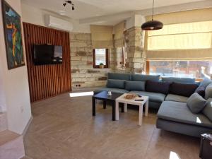 a living room with a blue couch and a table at Ракшиева Къща in Glavatartsi