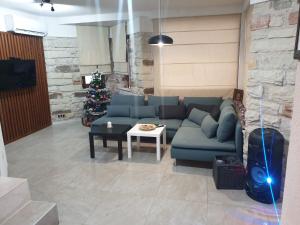 ein Wohnzimmer mit einer blauen Couch und einem Weihnachtsbaum in der Unterkunft Ракшиева Къща in Glavatartsi