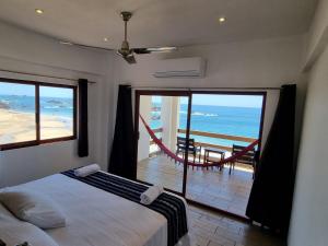 a bedroom with a bed and a view of the ocean at Posada Ziga Playa in Mazunte