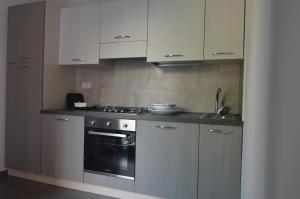 uma cozinha com armários brancos e um fogão em NEW Casa Corvaja em Taormina