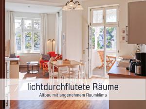 a kitchen and a living room with a table at Hunde ohne Aufpreis - Fewo Hagemeister Sellin - auch im Winter toll! Sauna im Haus - 6 Min zum Strand - 2 überdachte Balkone mit Strandkörben in Ostseebad Sellin +41 photos