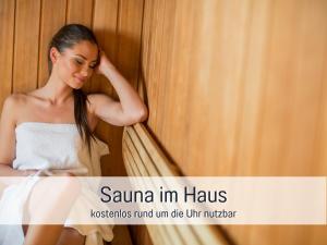una mujer con un vestido blanco sentada contra una pared en Fewo Hagemeister 6 Min zum Strand mit gratis Sauna & Coworking Space im Haus, en Ostseebad Sellin