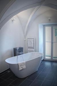 eine große weiße Badewanne in einem Zimmer mit Dachgeschoss in der Unterkunft Landhotel Schlappinger-Hof in Reisbach