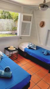 a room with two beds and a window at Villa Mambo in Sainte-Anne