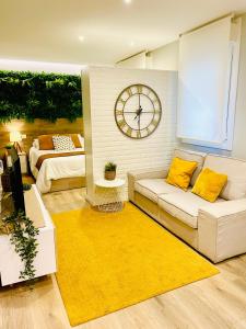 a living room with a couch and a clock on a wall at Loft centro Pontevedra in Pontevedra