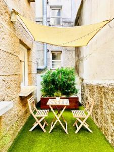 a patio with two chairs and a table and a plant at Loft centro Pontevedra in Pontevedra