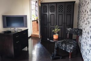 Habitación con TV, mesa y silla. en Gran Hotel París, en Cuenca