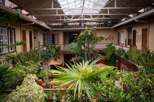 einen Innengarten mit Pflanzen und Bäumen in einem Gebäude in der Unterkunft Gran Hotel París in Cuenca