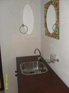 W łazience znajduje się umywalka i lustro. w obiekcie Clima Serrano w mieście Merlo