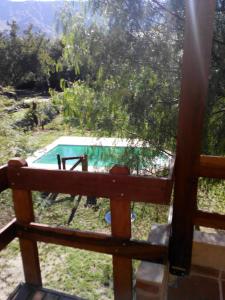 a view of a swimming pool from a wooden fence at Clima Serrano in Merlo