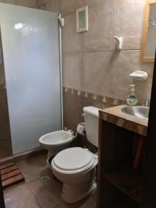 a bathroom with a toilet and a sink at Bendito Alcázar Cabañas in Colón