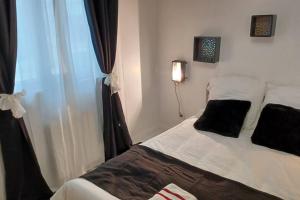 ein Schlafzimmer mit einem Bett mit schwarzen Kissen und einem Fenster in der Unterkunft Cozy Apartment, Airport CDG Exhibition Parc 14 min in Tremblay En France + 10 Fotos