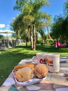 a table with a plate of biscuits and two cups of coffee at Bendito Alcázar Cabañas in Colón