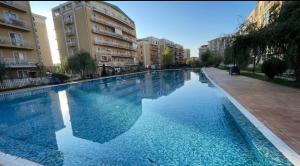 a large swimming pool in a city with buildings at Liberty Deluxe Apartment Cosmopolis in Creţuleasca