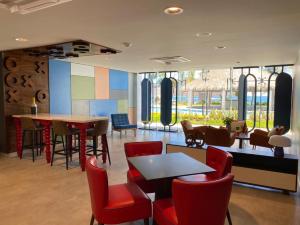 a restaurant with red chairs and tables and a colorful wall at Camino al Mar 802 Vista al Mar in Mazatlán