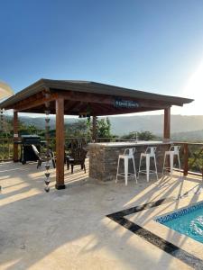un pabellón con mesa, sillas y piscina en Villa Valentina Holidays, en Camú