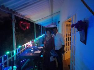 Ein Mann und eine Frau stehen vor einem Tisch mit Lichtern in der Unterkunft Hotel Casa la Gregorienne in La Vega
