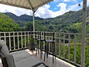 a balcony with chairs and tables and a view of mountains at Hotel Casa la Gregorienne in La Vega