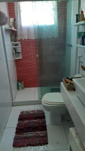 ein Badezimmer mit Toilette und roter Dusche in der Unterkunft Casa Aconchegante in Saquarema + 9 Fotos