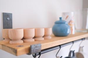 a wooden shelf with bowls and a blue vase on it at Burnside Cottage in Sleights