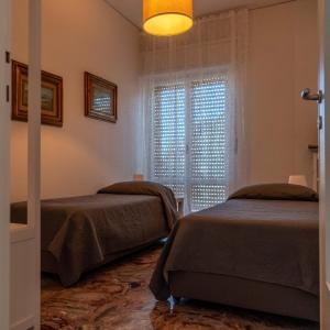 a bedroom with two beds and a window at Afrodite Loft Hermes in Verona